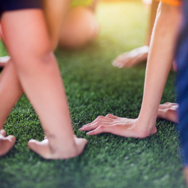 Children's hands on green artificial turf. Kid soccer training  football.