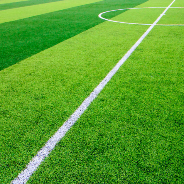 The white Line marking on the artificial green grass soccer field